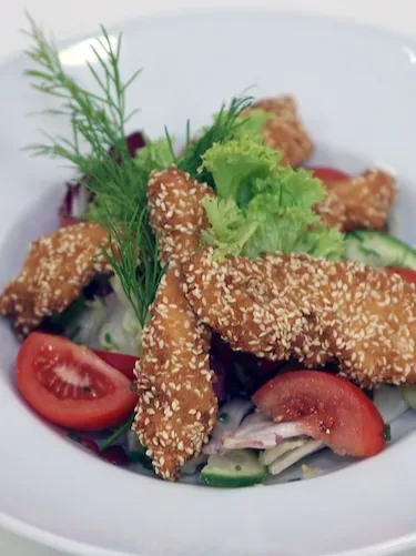 Salat mit gebackenen Hühnerbruststreifen im Sesammantel
